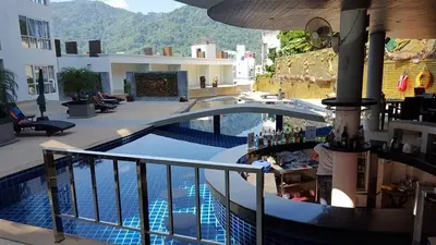 a swimming pool with a bar next to a building at Large, quiet Condo by รินดา Rinrada in Patong Beach