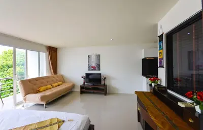 a living room with a couch and a flat screen tv at Large, quiet Condo by รินดา Rinrada in Patong Beach