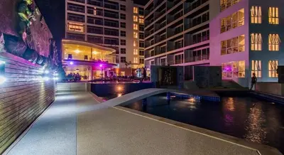 a pool in the middle of a city at night at Large, quiet Condo by รินดา Rinrada in Patong Beach