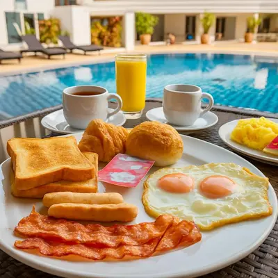 a plate of breakfast foods on a table with a pool at Large, quiet Condo by รินดา Rinrada in Patong Beach