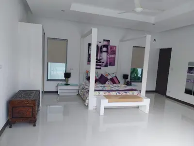 a white room with a bed and a table at Villa Destiny AZ in Ban Saiyuan (1)