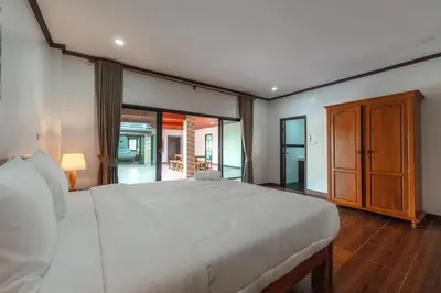 a bedroom with a large white bed and sliding glass doors at V155 4BR Large Family Villa Chalong in Chalong