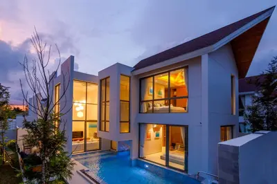 a house with a swimming pool at dusk at Elite Living - Design 3BR Pool Villa in Newly Built LuxPride 4 L6 Residence in Bang Tao Beach
