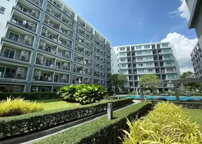 a large apartment building with trees and bushes at Luxury Residence in Phuket Center in Phuket Town