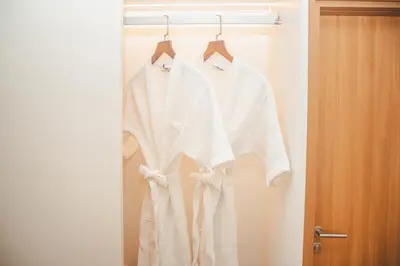 a group of white shirts hanging on a closet at Laguna Beachside residences apartamens, walking distance to the sea in Bang Tao Beach
