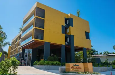 a yellow building in front of a building at Laguna Beachside residences apartamens, walking distance to the sea in Bang Tao Beach
