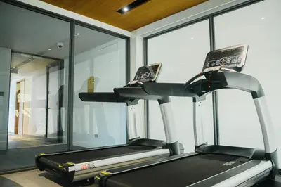 a gym with a treadmill in a room with windows at Laguna Beachside residences apartamens, walking distance to the sea in Bang Tao Beach