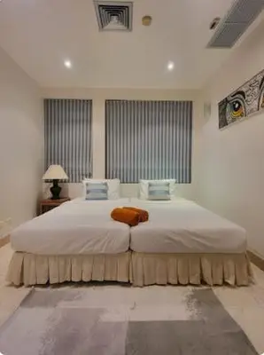 a bedroom with a large bed with white sheets and blue pillows at Heavenly place in Surin Beach