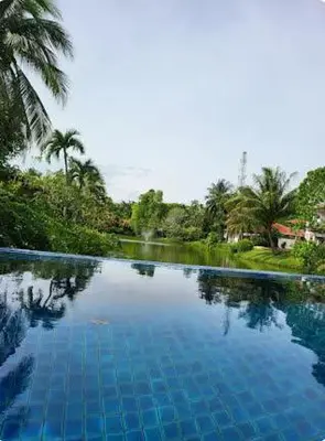 a pool of blue water with trees in the background at Heavenly place in Surin Beach