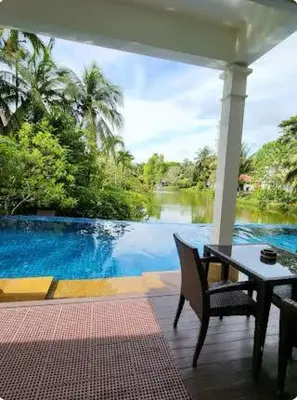 a patio with a table and a view of a river at Heavenly place in Surin Beach