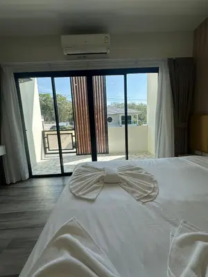 a bedroom with a white bed with a large window at Sleep At Airport in Nai Yang Beach