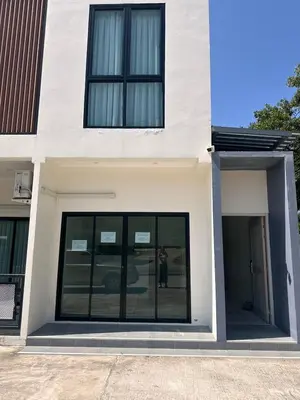 a white building with black windows on the side of it at Sleep At Airport in Nai Yang Beach