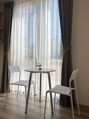 a table and two chairs in front of a window at Sleep At Airport in Nai Yang Beach