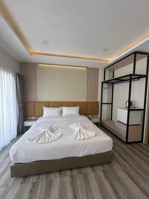 a bedroom with a large bed with white sheets at Sleep At Airport in Nai Yang Beach
