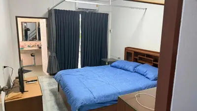 a bedroom with a blue bed and a mirror at Chalong Paradise Guesthouse in Ban Bang Chak