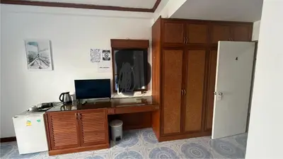 a room with a desk with a computer and a tv at Chalong Paradise Guesthouse in Ban Bang Chak
