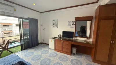 a room with a mirror and a desk with a television at Chalong Paradise Guesthouse in Ban Bang Chak