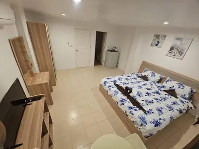 a bedroom with a bed with a blue and white sheets at Chalong Paradise Guesthouse in Ban Bang Chak