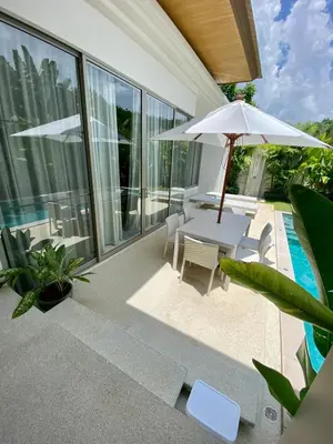 a patio with an umbrella and a table and chairs at Trichada Sky 3bed villa, Bangtao, Laguna in Phuket