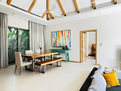a dining room with a table and a couch at Trichada Sky 3bed villa, Bangtao, Laguna in Phuket