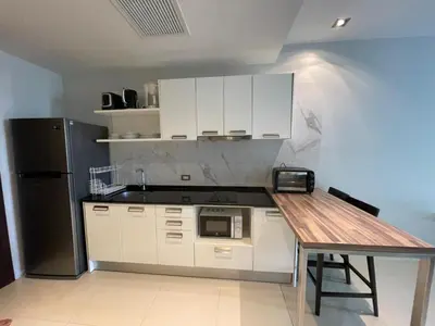 a kitchen with white cabinets and a black refrigerator at Emerald Terrace Condo 10-Family One Bed & Sofa Bed Garden View in Patong Beach