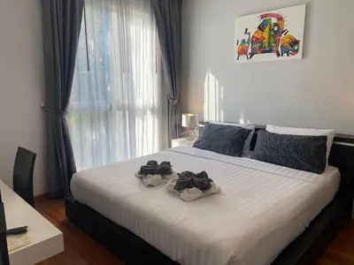 a bedroom with a bed with two flowers on it at Emerald Terrace Condo 10-Family One Bed & Sofa Bed Garden View in Patong Beach