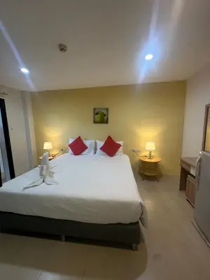 a bedroom with a large bed with red pillows at Theclickguesthouse in Ban Bang Chak