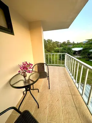 a balcony with a table and two chairs and a table at Theclickguesthouse in Ban Bang Chak
