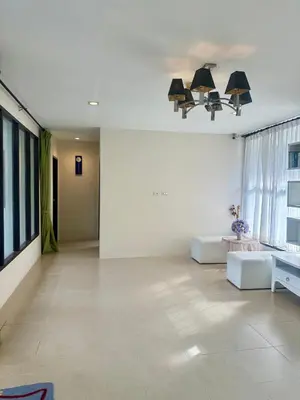 a living room with white walls and a large window at Theclickguesthouse in Ban Bang Chak