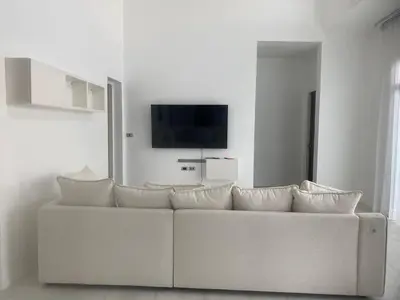 a white couch with pillows in a living room at Phuket Mali house in Ban Sam Kong
