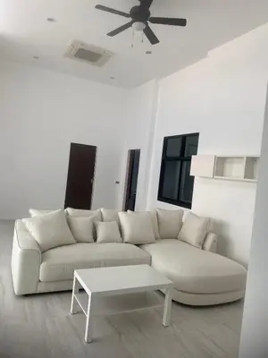 a white living room with a white couch and a table at Phuket Mali house in Ban Sam Kong