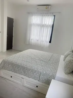 a bed in a white room with a window at Phuket Mali house in Ban Sam Kong