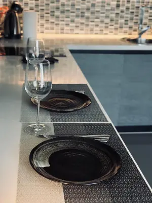 a table with two plates and wine glasses on it at Citygate Kamala Condo Paris in Kamala Beach