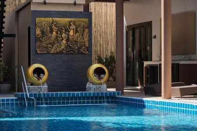 a pool at a hotel with a painting on the wall at Blue Palm Residence Kata in Kata Beach