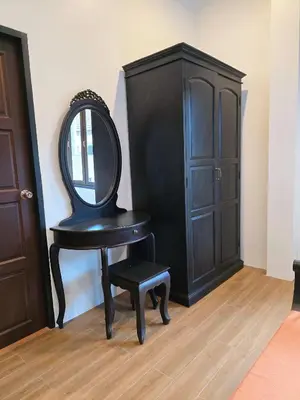 a chair with a mirror sitting next to a cabinet at Blue Palm Residence Kata in Kata Beach