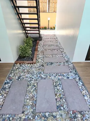 a zen garden with rocks and a stairway at Blue Palm Residence Kata in Kata Beach