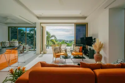 a living room with orange furniture and a large window at Seaview Villa Near Naithon Beach Phuket in Nai Thon Beach