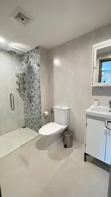 a bathroom with a toilet and a shower and a sink at The Title Residencies Naiyang in Phuket