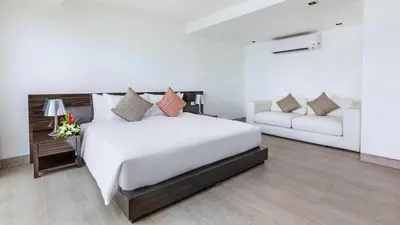a bedroom with a white bed and a couch at Ocean's 11 Villa in Thalang
