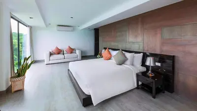 a bedroom with a large white bed and a couch at Ocean's 11 Villa in Thalang