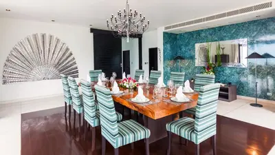a dining room with a wooden table and chairs at Ocean's 11 Villa in Thalang