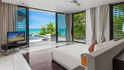 a living room with a television and large windows at Ocean's 11 Villa in Thalang
