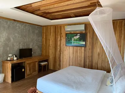 a bedroom with a bed and a flat screen tv at Thiwson Beach Resort - SHA Extra Plus in Ko Yao Yai