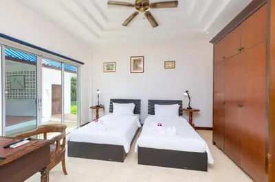 a bedroom with two beds and a ceiling fan at Villa Valentine Phuket in Ban Thalat Choeng Thale