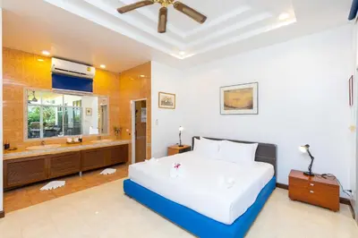a bedroom with a large bed and a bath tub at Villa Valentine Phuket in Ban Thalat Choeng Thale