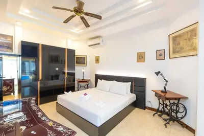 a bedroom with a bed and a ceiling fan at Villa Valentine Phuket in Ban Thalat Choeng Thale
