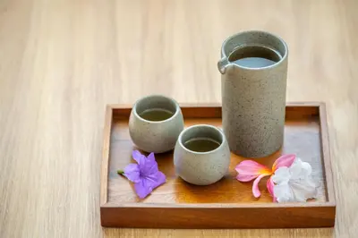 a wooden tray with three cups and flowers on it at AZ Sunrise Resort & Fitness Club in Layan Beach