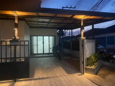 awning over a porch of a house with a motorcycle at Mali Villa in Ban Suan