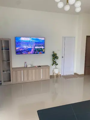 a living room with a flat screen tv on the wall at Mali Villa in Ban Suan