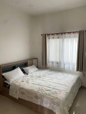 a bedroom with a large bed with a window at Mali Villa in Ban Suan